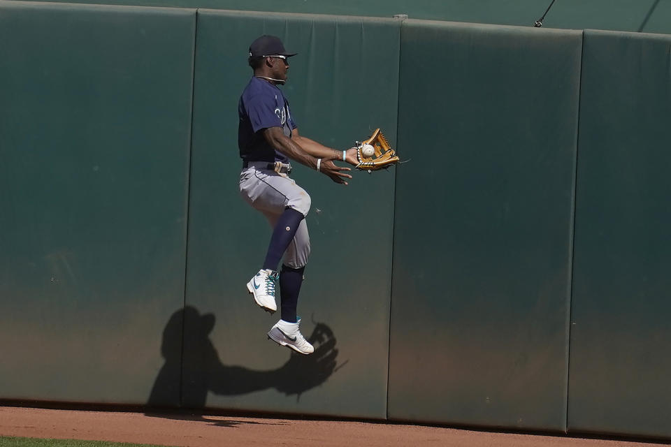 Seattle Mariners center fielder Kyle Lewis cannot catch a two-run double hit by Oakland Athletics' Mark Canha during the seventh inning of a baseball game in Oakland, Calif., Sunday, Sept. 27, 2020. (AP Photo/Jeff Chiu)