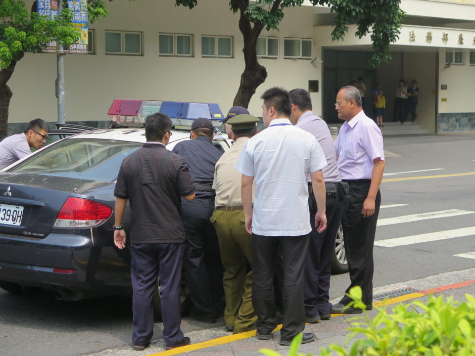 總統府四號門憲兵遭持刀攻擊，行凶者被警察抬上警車。（圖／讀者提供 , 2017.08.18）