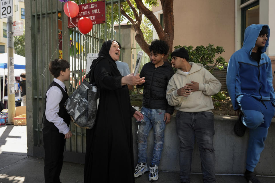 Tatiana Alabsi, second from left, talks with teenagers during an Eid celebration in the Tenderloin neighborhood Saturday, April 20, 2024, in San Francisco. (AP Photo/Godofredo A. Vásquez)
