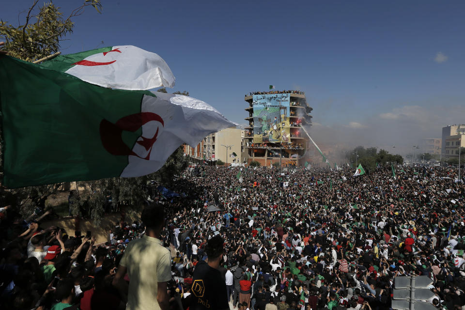 Demonstrators carry a giant Algerian flag during a protest in Bordj Bou Arreridj, east of Algiers, Friday, April 26, 2019. Algerians are massing for a 10th week of protests against their country's ruling class, calling for the ex-president's brother to be put on trial. (AP Photo/Toufik Doudou)