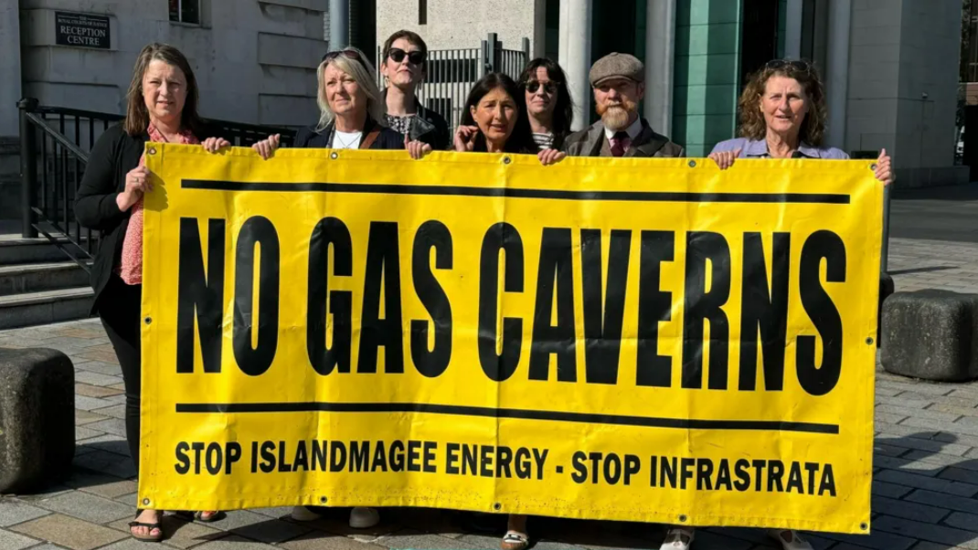 Campaigners standing outside Belfast Laganside Court holding a banner reading "No gas caverns" 