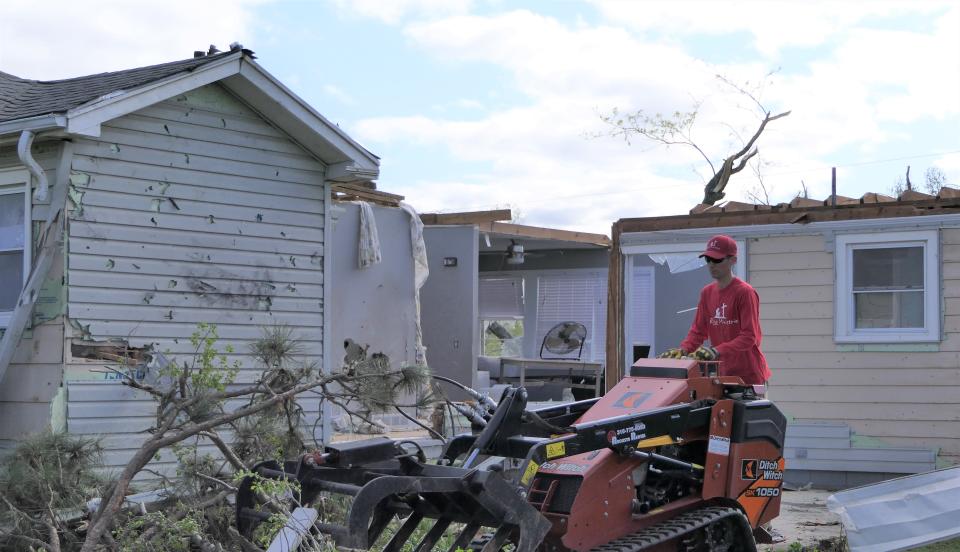 Heath Williamson, of Rapid Ministries in Douglass, on Saturday clears debris out of the Linville home that was destroyed by a tornado the night before in Andover.