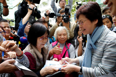 Chief Executive election candidate and former Chief Secretary Carrie Lam signs autographs for supporters during an election campaign in Hong Kong, China March 23, 2017. REUTERS/Tyrone Siu