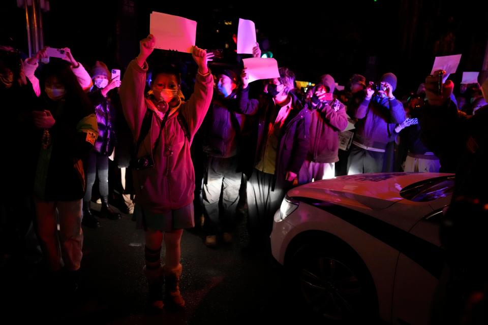 Protesters hold up blank papers and chant slogans as they march in protest in Beijing, Sunday, Nov. 27, 2022. Protesters angered by strict anti-virus measures called for China's powerful leader to resign, an unprecedented rebuke as authorities in at least eight cities struggled to suppress demonstrations Sunday that represent a rare direct challenge to the ruling Communist Party.