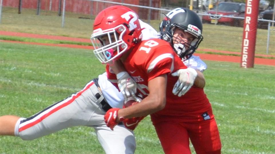 Chris Carr of Haddonfield has a grip on Paulsboro's Sharif Green (18) after Green's fourth-quarter reception during their West Jersey Football League game at Paulsboro's Bennett Field on Saturday, September 3, 2022.