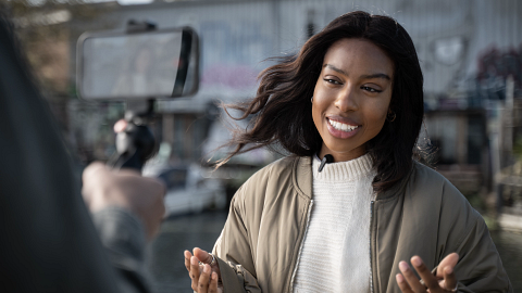  A woman journalist using the new Shure MoveMic outdoors. . 