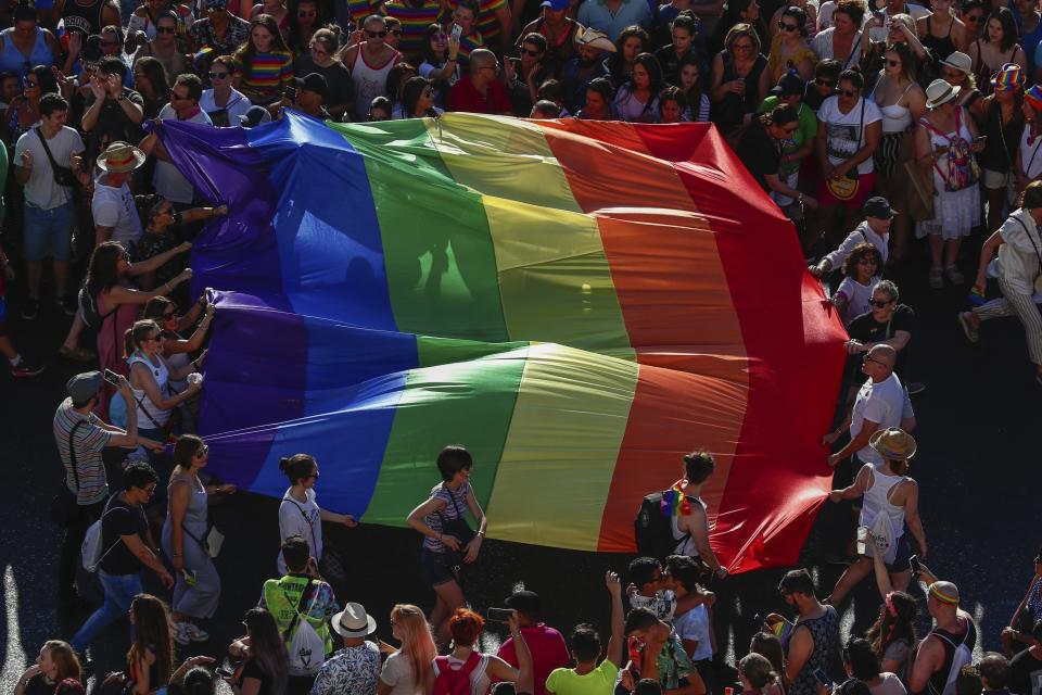 FILE - In this file photo dated Saturday, July 6, 2019, participants of the annual LGBTQ pride parade carry the emblematic rainbow flag in Madrid, Spain. The Spanish Cabinet on Tuesday June 29, 2021, passed a draft bill on LGBTQ rights that will seek parliamentary approval to allow transgender people over 16 years old to freely change their gender and name in the official registry without doctors or witnesses intervening in the process. (AP Photo/Manu Fernandez)