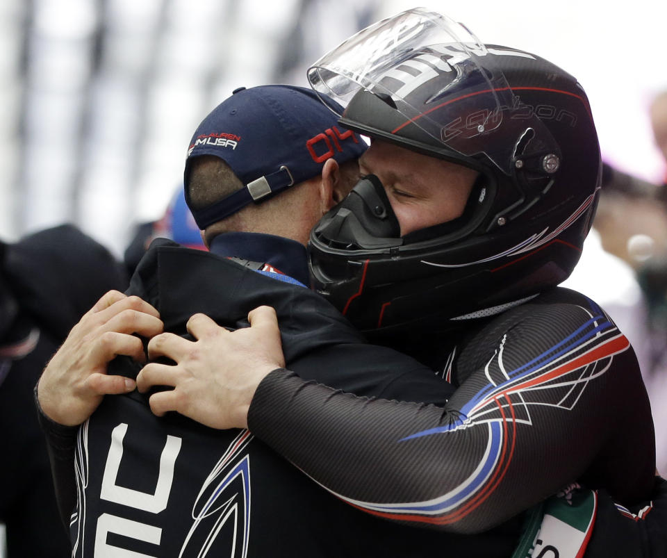 The driver of United States USA-1, Steven Holcomb, hugs a coach after the team won the bronze medal during the men's four-man bobsled competition final at the 2014 Winter Olympics, Sunday, Feb. 23, 2014, in Krasnaya Polyana, Russia. (AP Photo/Dita Alangkara)