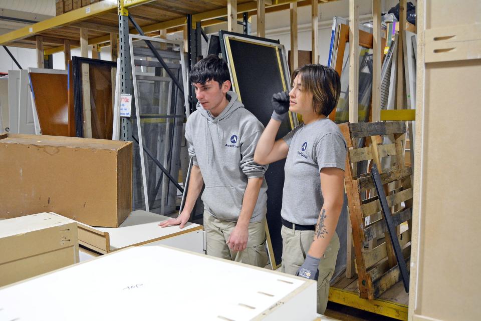 Leah Rezac and Charlie Saunders work to move cabinetry Wednesday in an aisle at the Habitat for Humanity ReStore. They are part of an AmeriCorps service worker team in Columbia through Dec. 18 as part of a National Civilian Community Corps project.