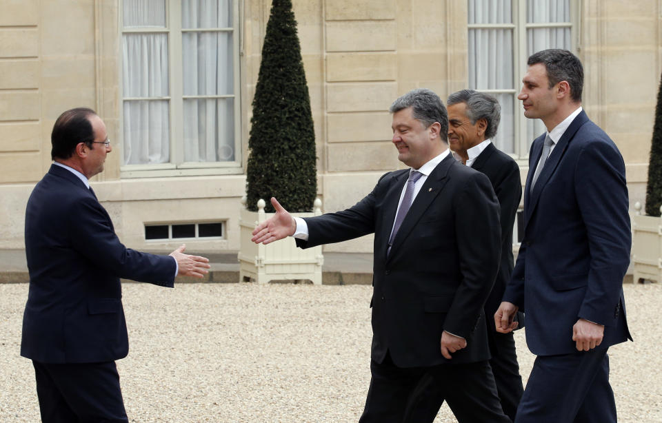 French President Francois Hollande, left, greets Vitali Klitschko former heavyweight boxing champion and Ukrainian leader of UDAR party, right, former Ukrainian foreign minister Petro Porochenko, center, and French philosopher and writer Bernard Henri Levy as they arrive for a meeting at the Elysee Palace, in Paris, Friday, March 7, 2014. The Ukrainian politicians will discuss the current situation in Ukraine with the French President. (AP Photo/Christophe Ena)