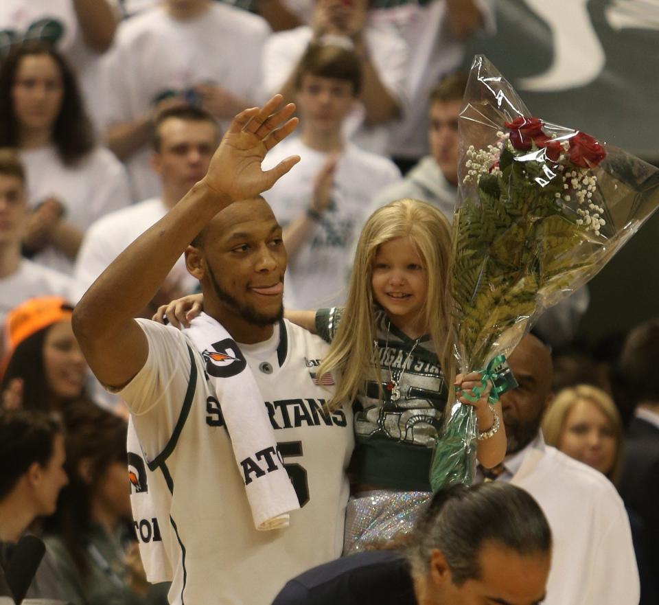 Michigan State senior center Adreian Payne carries his special guest Lacey Holsworth onto the court where he was honored with fellow seniors on March 6, 2014, at the Breslin Center in East Lansing.
