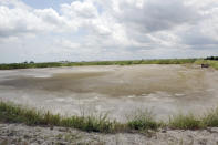 FILE - In this June 23, 2014 file photo, the dried-up bed of an inactive coal ash pond is seen at Duke Energy's Sutton plant in Wilmington, N.C. Duke Energy says heavy rains from Florence have caused a slope to collapse at a coal ash landfill at a closed power station near the North Carolina coast. Duke spokeswoman Paige Sheehan said Saturday night, Sept. 15, 2018, that about 2,000 cubic yards of ash have been displaced at the L. V. Sutton Power Station outside Wilmington. (Mike Spencer/The Star-News via AP)