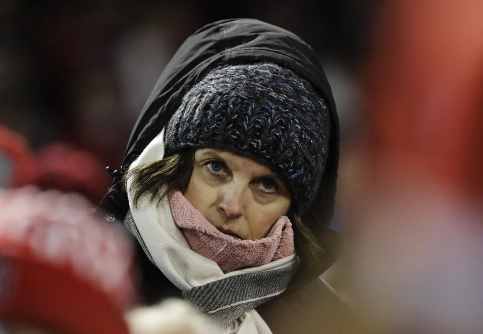 FILE - In this Oct. 23, 2018, file photo, a bundled-up spectator watches Game 1 of baseball's World Series between the Boston Red Sox and the Los Angeles Dodgers in Boston. The 2020 regular season was scheduled to end on Sept. 27, but it's possible games could be pushed well into October or November. That probably wouldn't be a huge problem in warm-weather cities like Houston and Los Angeles or places with retractable roofs, such as Toronto. But November night games in Minneapolis, Chicago or Boston? Brrrrr. (AP Photo/David J. Phillip, File)