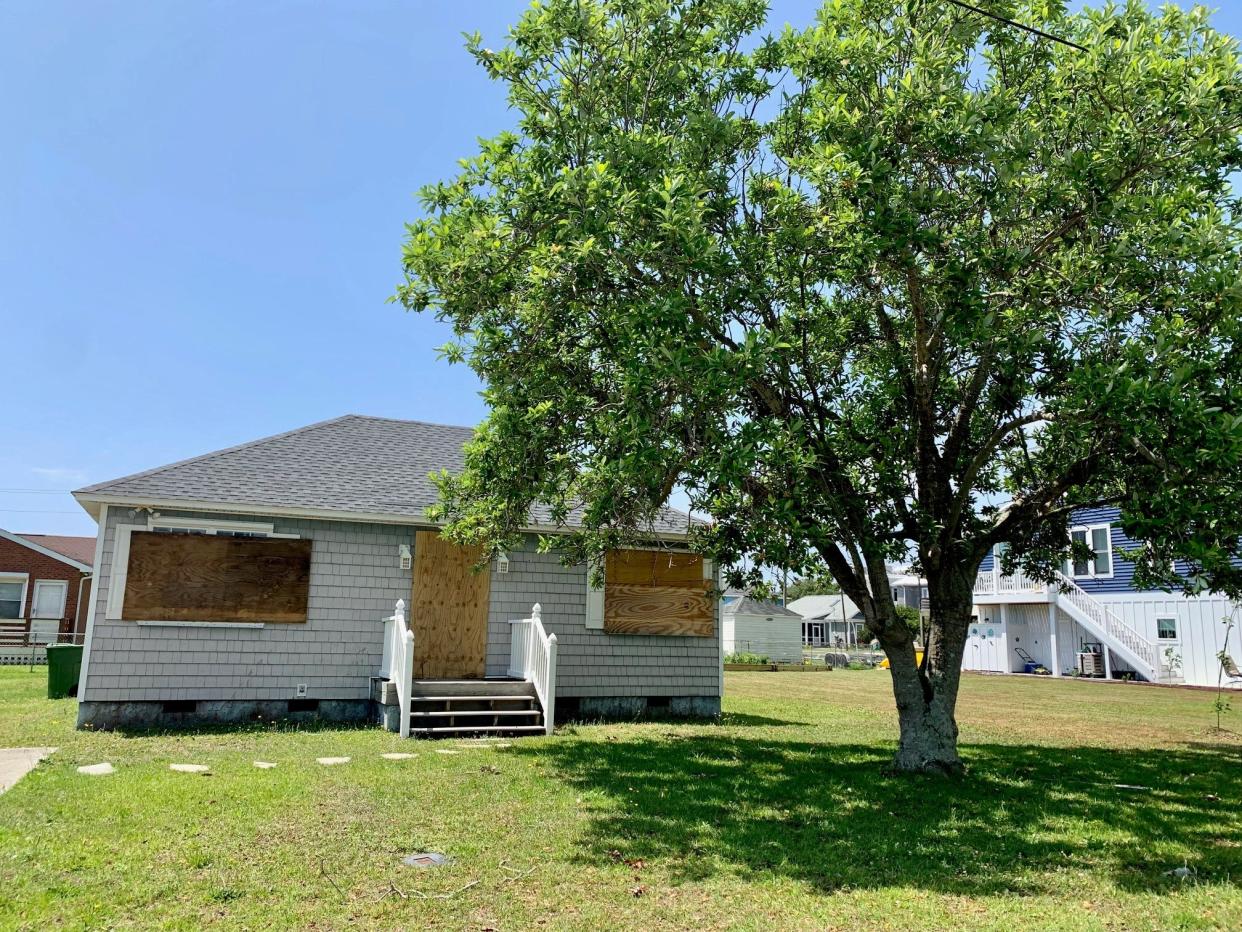 The house at 121 Ocean View Avenue in Kure Beach is boarded up Thursday, May 26, 2022 -- more than a week after a dispute between neighbors left two men dead.