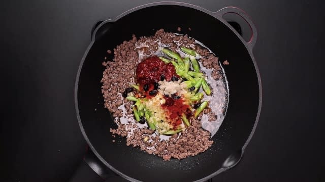 Stir frying beef, french beans, and chilli bean paste ingredients in frying pan