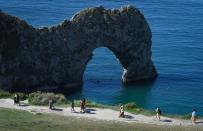 <p>Named after the limestone arch sitting on the water between St Oswald's Bay and Man O'War Cove, Durdle Door is one of the most beautiful sights on the Jurrasic Coast. It's a bit of a trek - to find yourself on the beautiful beach taking in the view, you have to climb down the cliff. But it's worth it when you reach the bottom and get yourself a spot sitting by the crystal clear water and listening to the calming breeze.</p><p><a class="link " href="https://www.booking.com/index.en-gb.html?label=gen173nr-1BCAEoggI46AdIM1gEaFCIAQGYAQm4ARfIAQzYAQHoAQGIAgGoAgO4ArKWtJ8GwAIB0gIkN2NmMDYwYTUtODNjYS00MWFlLWEzOWQtZTQzZTJiYzRmMWU42AIF4AIB&keep_landing=1&sb_price_type=total" rel="nofollow noopener" target="_blank" data-ylk="slk:FIND ACCOMODATION;elm:context_link;itc:0;sec:content-canvas">FIND ACCOMODATION</a></p>