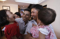 Reuters reporters Wa Lone, center right, and Kyaw Soe Oo, center left, hold their children after being freed from prison, in Yangon, Myanmar, Tuesday, May 7, 2019. The two journalists who were imprisoned for breaking Myanmar's Official Secrets Act over reporting on security forces' abuses of Rohingya Muslims were pardoned and released Tuesday, the prison chief and witnesses said. (Ann Wang/Pool Photo via AP)