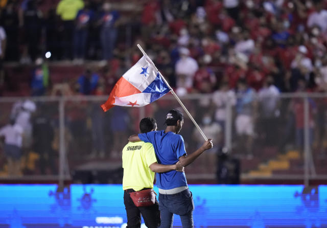 A security guard escorts a Panama fan off the field at the end of a qualifying soccer match against the United States for the FIFA World Cup Qatar 2022 at Rommel Fernandez stadium, in Panama city, Panama, Sunday, Oct. 10, 2021. Panama won 1-0. (AP Photo/Arnulfo Franco)