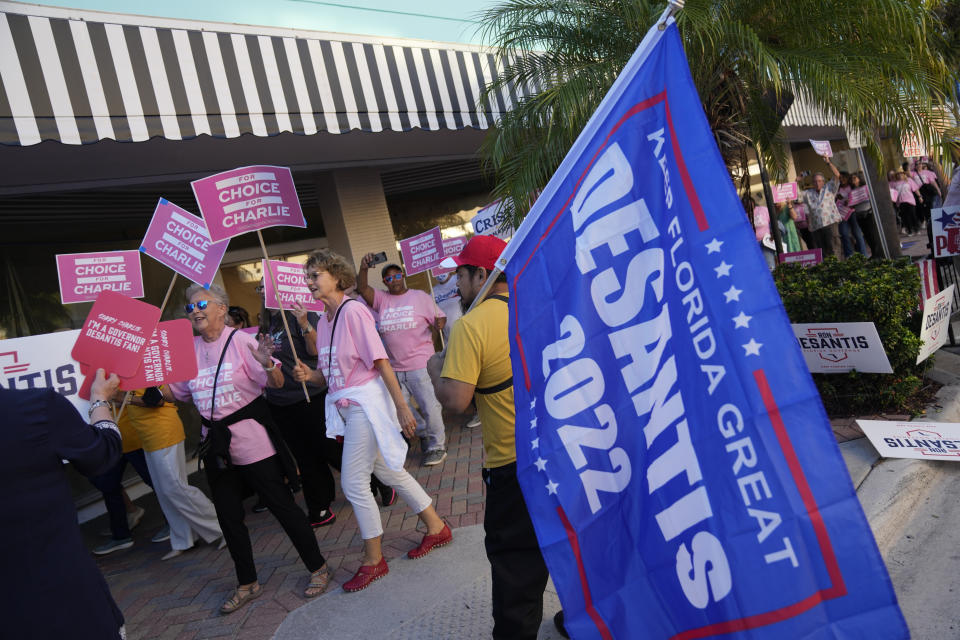 Supporters of Democratic candidate for governor Charlie Crist march past a supporter of Florida's Republican Gov. Ron DeSantis, as they arrive at the Sunrise Theatre ahead of a debate between DeSantis and Crist, in Fort Pierce, Fla., Monday, Oct. 24, 2022.(AP Photo/Rebecca Blackwell)