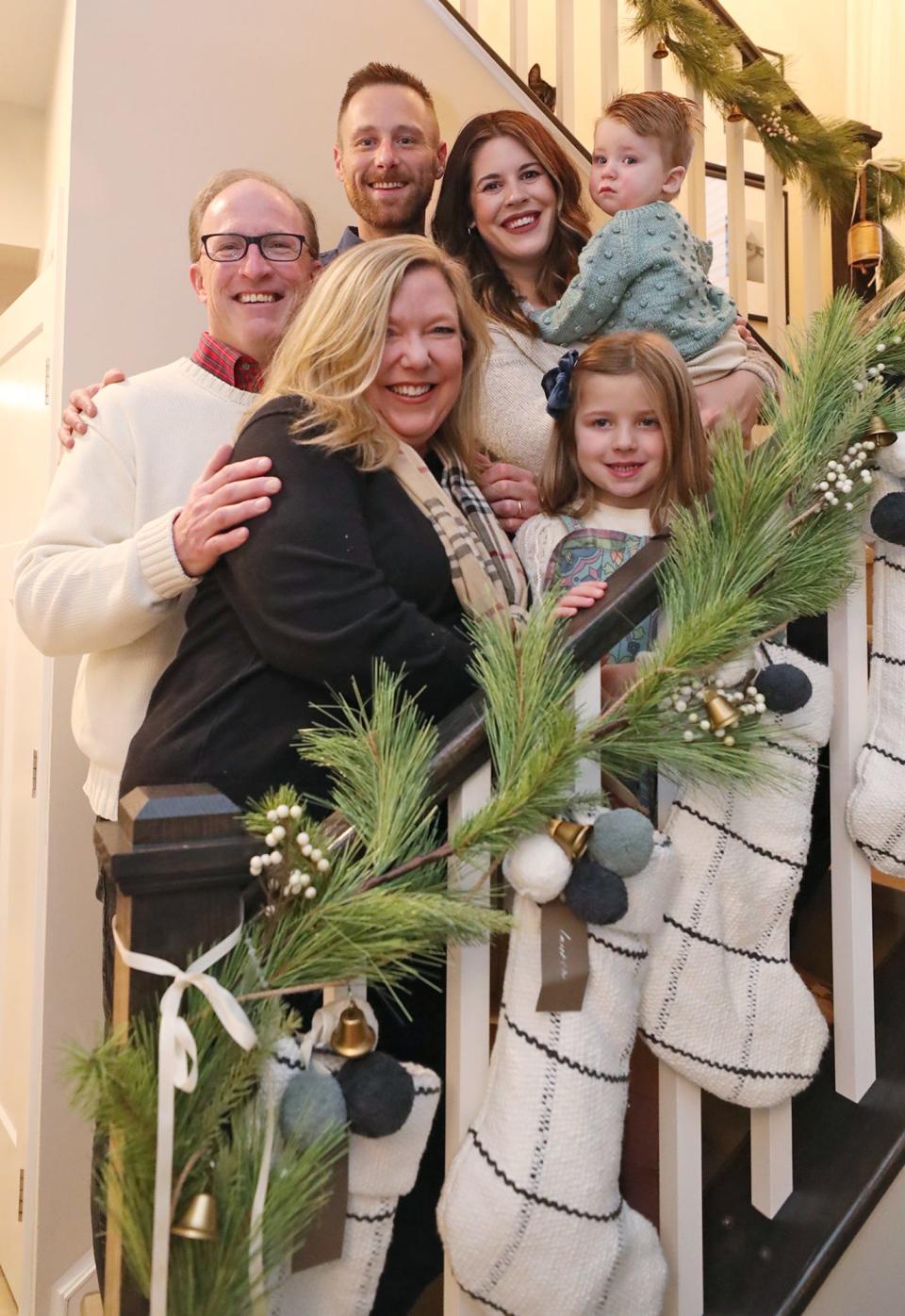 Surrogate grandparents Rich and Lara Wilson join Nick and Cassie Horvath with Graham, 9 months, and LJ, 5, on the stairs for a group photo at the Horvath's Lafayette Township home.