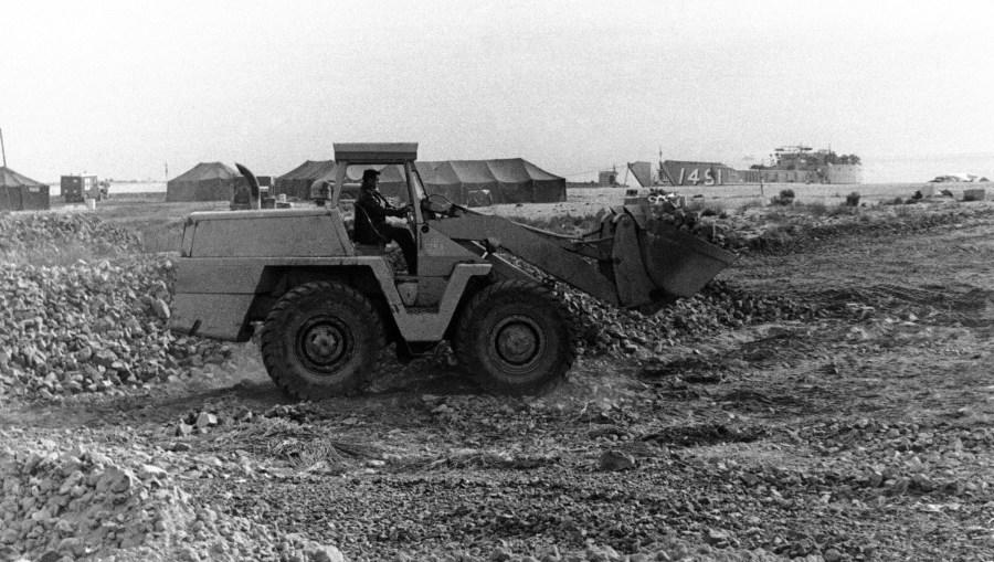 A U.S. Air Force bulldozer cleans up rubble at the base camp from which the long search for a missing nuclear bomb continues in Palomares Beach, Spain on Feb. 11, 1966. (AP Photo)