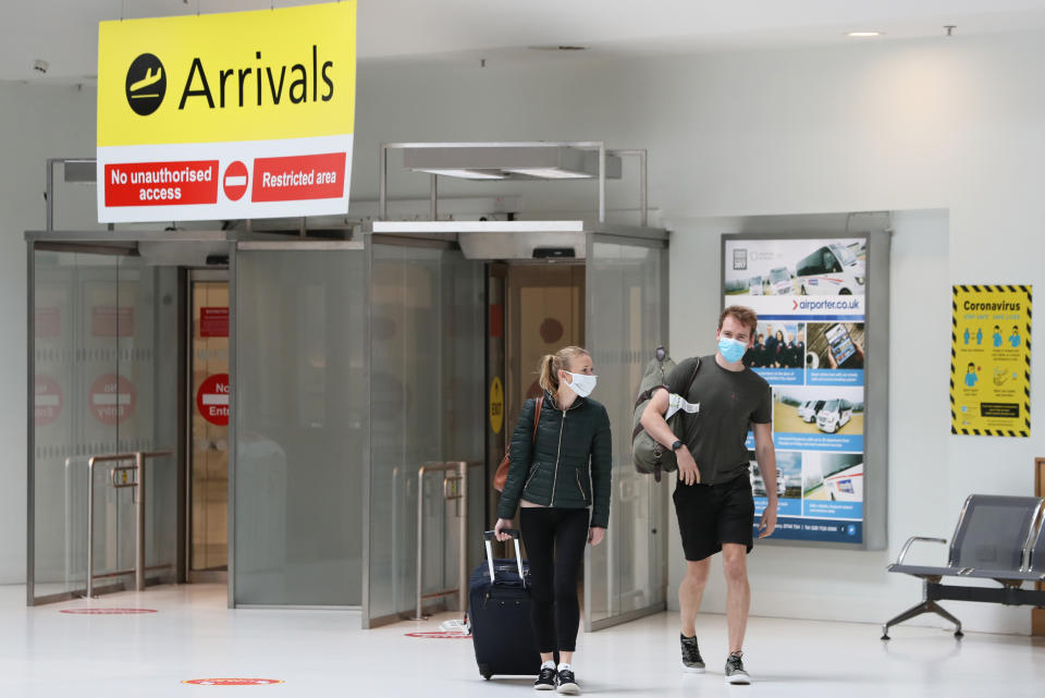 People wear facemasks as they arrive at Belfast City Airport after face coverings on public transport became mandatory on Friday.