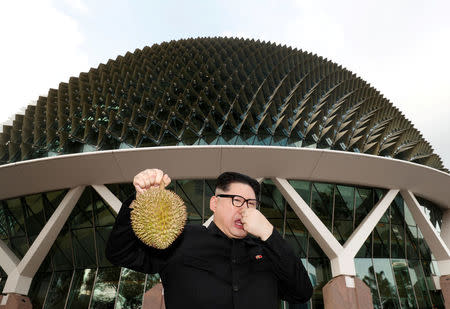 Howard, an Australian-Chinese impersonating North Korean leader Kim Jong Un, poses with a durian at the Esplanade in Singapore May 27, 2018. REUTERS/Edgar Su