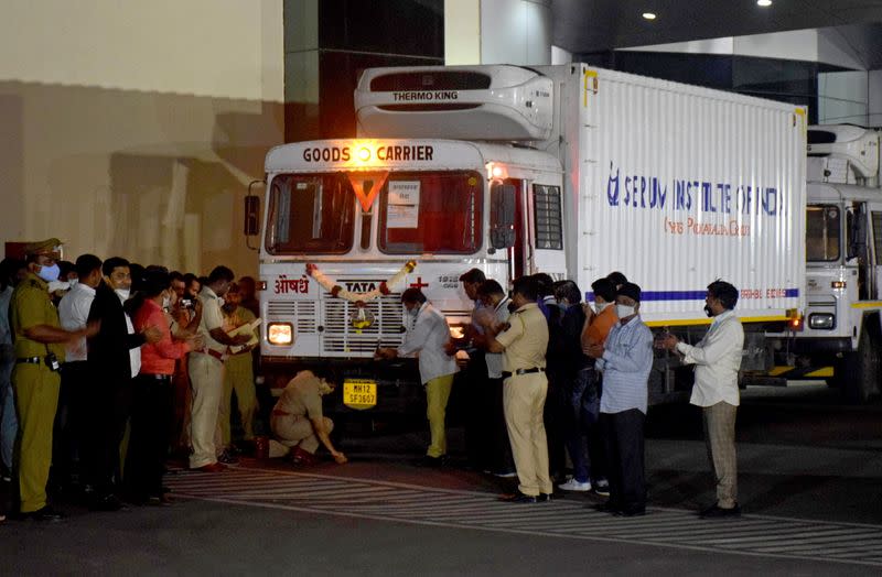 A police officer performs prayers in front of a truck carrying first consignment of COVISHIELD before it leaves from Serum Bio-Pharma Park of Serum Institute of India, for its distribution, in Pune