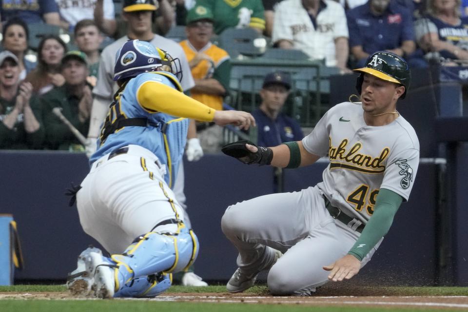 Oakland Athletics' Ryan Noda slides home safely under the tag of Milwaukee Brewers catcher William Contreras during the first inning of a baseball game Friday, June 9, 2023, in Milwaukee. (AP Photo/Morry Gash)