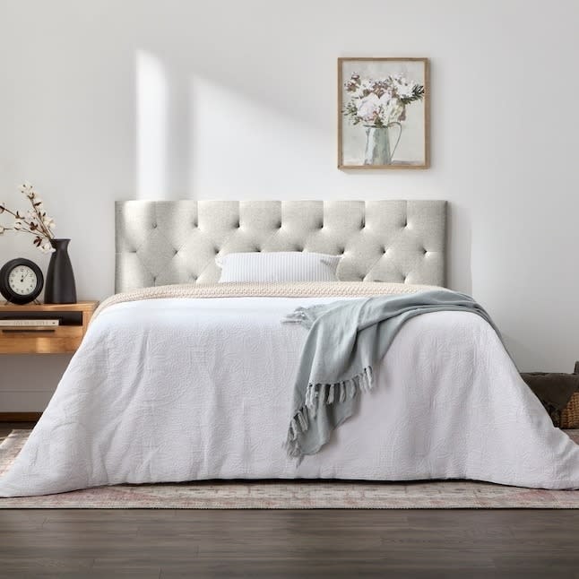 the cream headboard on a bed