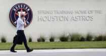 Houston Astros Senior Director of Business Operations Dan O'Neill walks past signs outside of the Houston Astros spring training baseball facility at the Fitteam Ballpark of The Palm Beaches, in West Palm Beach, Fla., Wednesday, Feb. 12, 2020. (Karen Warren/Houston Chronicle via AP)