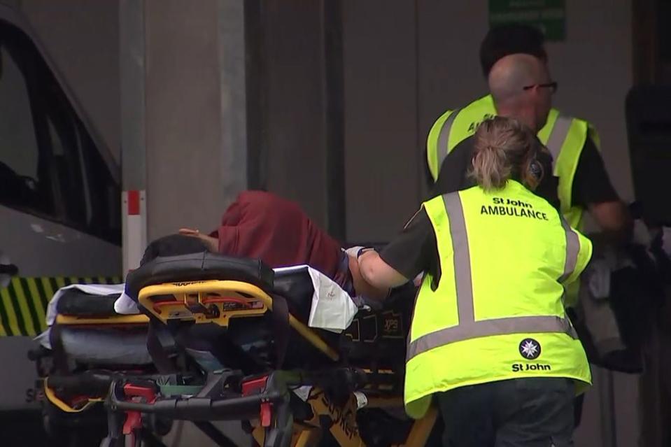 Authorities assist a victim of the New Zealand mosque shooting Friday