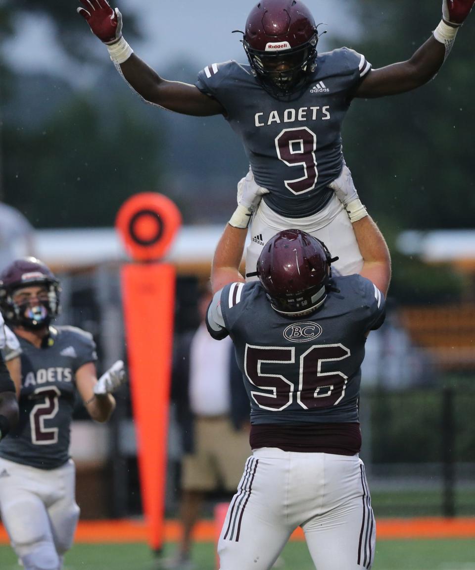 Benedictine's Lamont Mitchell (9) celebrates with teammate Drew Morin after scoring a touchdown.