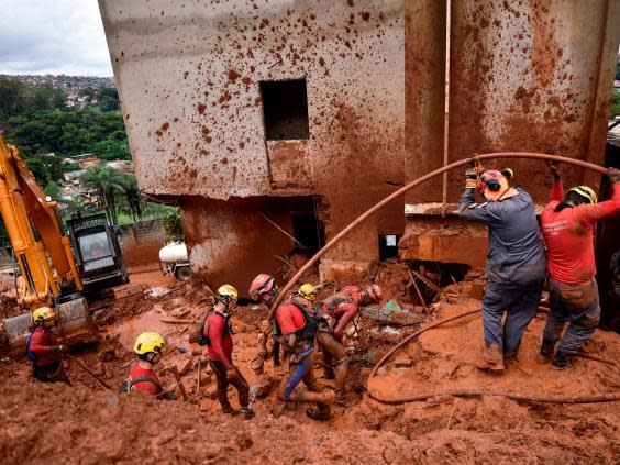 Firefighters search for missing persons using a hydraulic dismantling technique, which uses water to disperse mud, in Belo Horizonte (AFP via Getty Images)