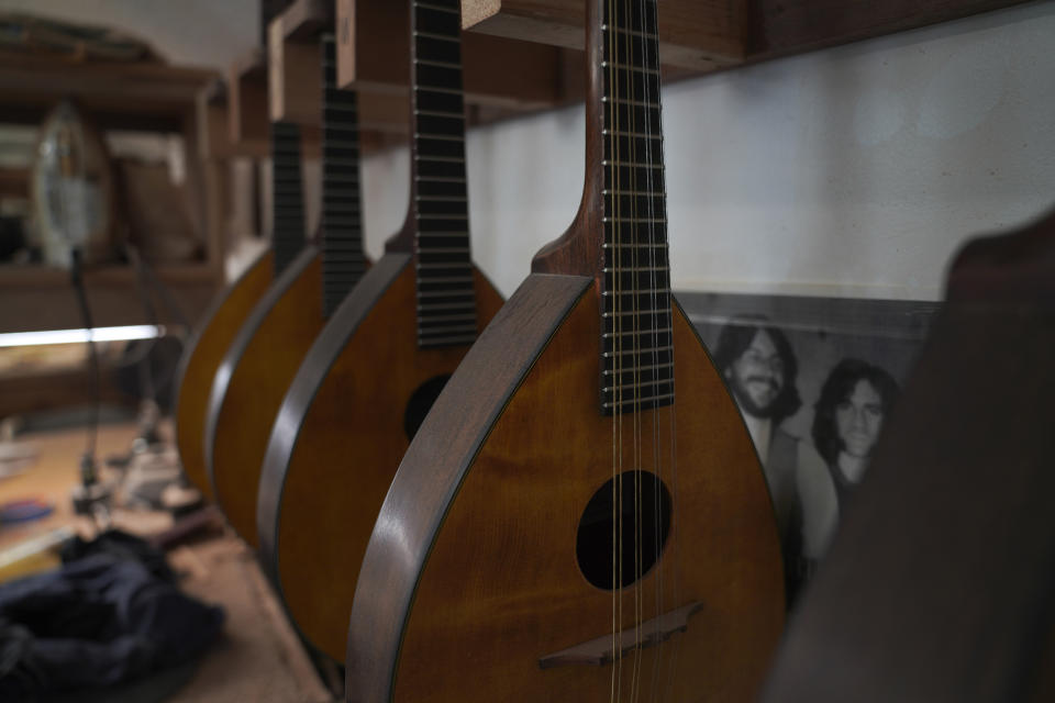 A row of handcrafted mandolins lines the wall of Mike Dulak's workshop in Rocheport, Mo., Friday, Sept. 8, 2023. Over the past 30 years, Dulak has made thousands of mandolins, and says he finds a sense of spirituality in working with the wood, just as he does playing his guitar. But Dulak, along with the largest group of Americans, does not associate himself with any religion. (AP Photo/Jessie Wardarski)