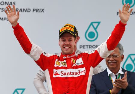 Ferrari's Sebastian Vettel celebrates winning the Malaysian Grand Prix on the podium. Reuters / Olivia Harris