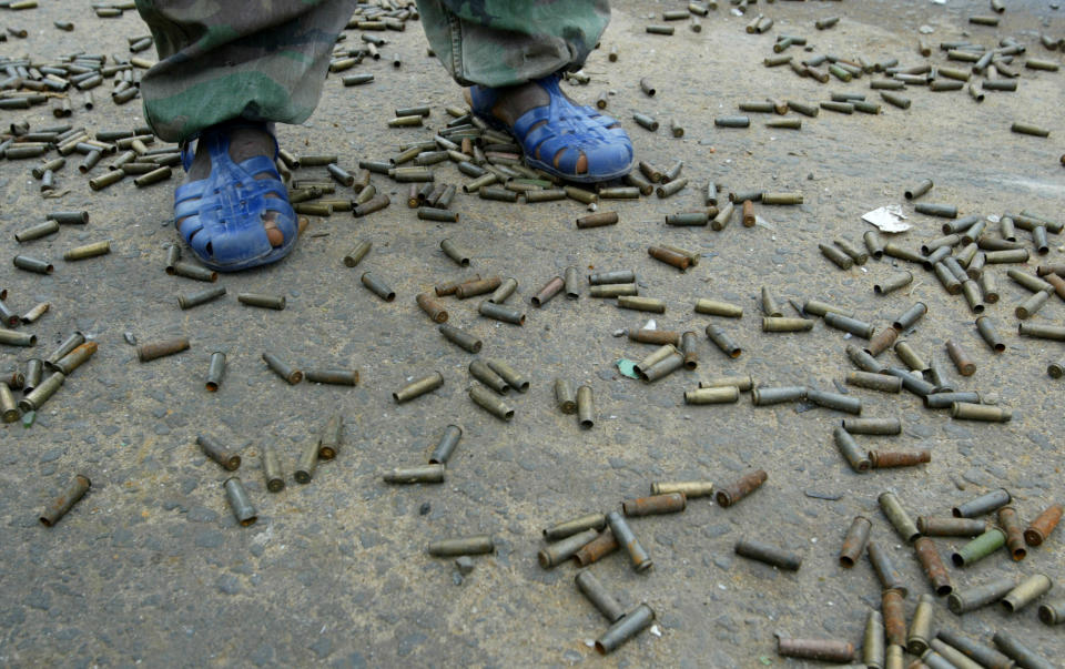 <p>A Liberians United for Reconciliation and Democracy (LURD) stands among hundreds of shell casings August 6, 2003 in Monrovia, Liberia. LURD rebels still hold positions on the edge of downtown Monrovia, staying in place as peacekeepers try bring the rebels and Liberian government together for meetings. (Photo by Chris Hondros/Getty Images) </p>