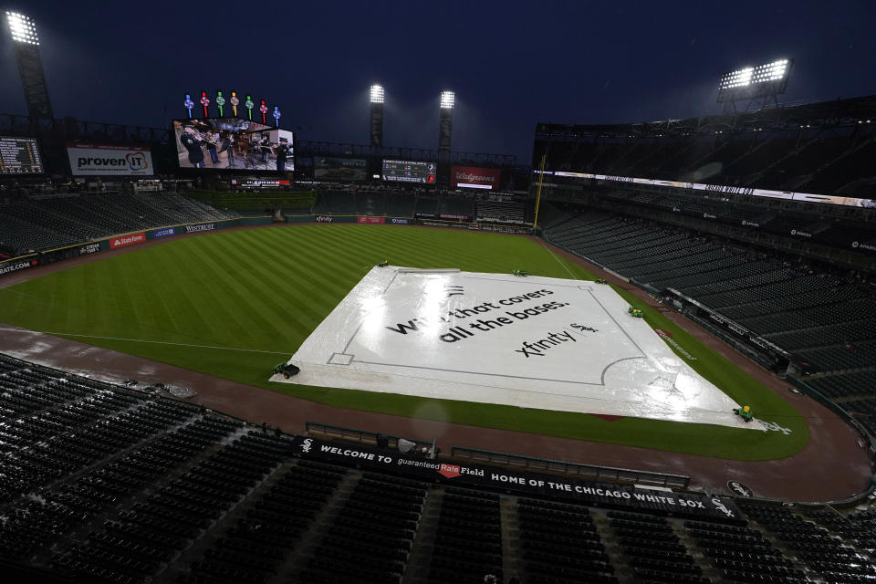A tarp covers the infield during a rain delay before a baseball game between the Baltimore Orioles and the Chicago White Sox in Chicago, Friday, May 28, 2021. (AP Photo/Nam Y. Huh)