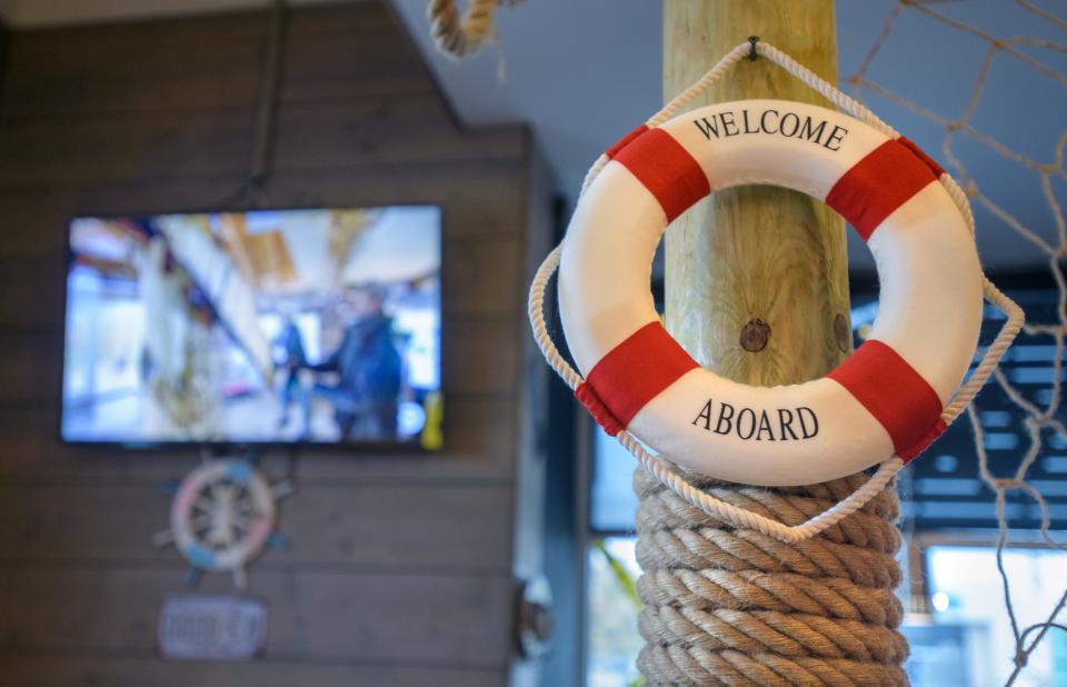 A decorative life preserver hangs from a wooden post at the new Holy Crab seafood restaurant in East Peoria. Television sets can be view from nearly any spot in the restaurant.
