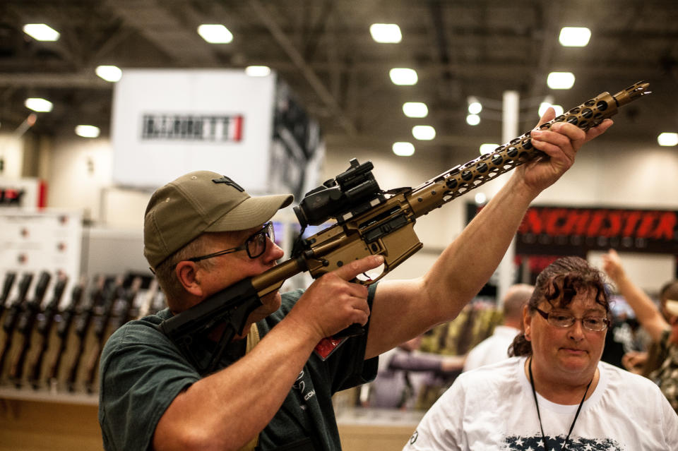 Tim Oelklaus of Missouri holds up a display rifle on the expo floor of the annual NRA meeting in Dallas,&nbsp;Texas, on May 4. (Photo: Joseph Rushmore for HuffPost)