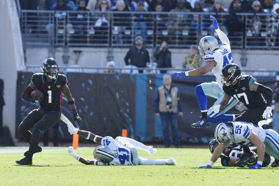 Jacksonville Jaguars running back Travis Etienne Jr. (1) eludes defenders as he runs for a first down during first quarter action. The Jacksonville Jaguars hosted the Dallas Cowboys at TIAA Bank Field Sunday, December 18, 2022. The Jaguars trailed 21 to 7 at the half. [Bob Self/Florida Times-Union]