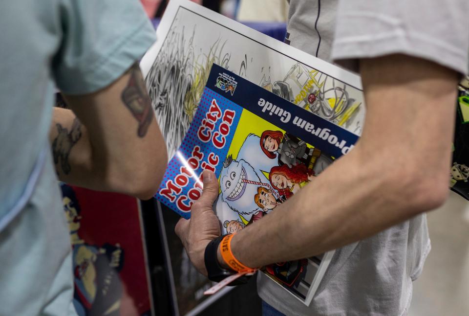 A fan holds a 2024 Motor City Comic Con booklet inside the Suburban Collection Showplace in Novi on Saturday, May 18, 2024.