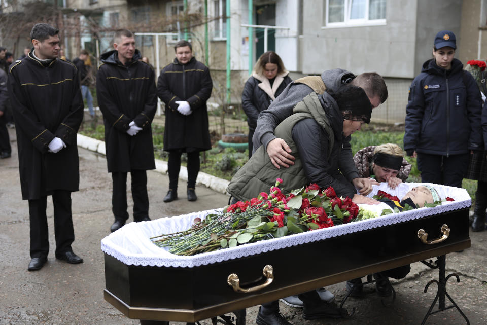 Family members of Vitaliy Alimov, his mother Maria and his wife Natalia, mourn over his body before his funeral in Bilhorod-Dnistrovskyi, Ukraine, Monday March 18, 2024. Alimov, a firefighter, was killed in the Russian attack on Odesa on Friday March 15. (AP Photo/Victor Sajenko)