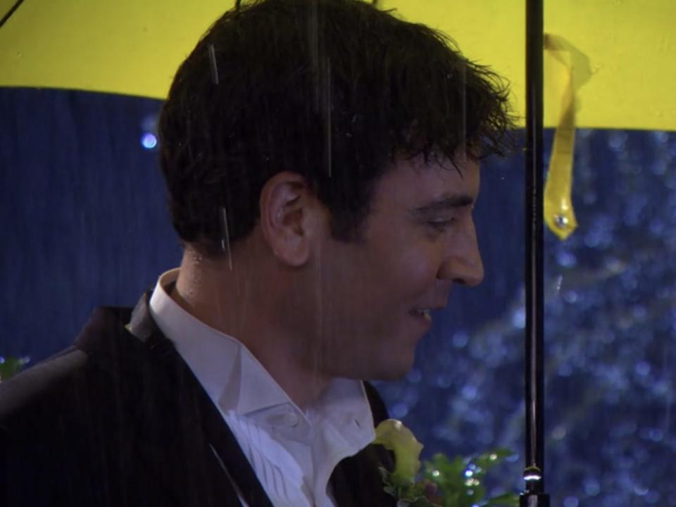 ted and tracy standing under a yellow umbrella on how i met your mother