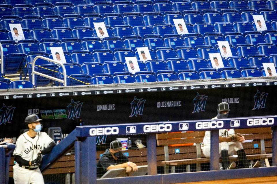 Photos of Miami Marlins players who contracted the novel coronavirus are pasted onto seats in the stands during a Major League Baseball game against the Atlanta Braves at Marlins Park in Miami, Florida on Sunday, August 16, 2020.
