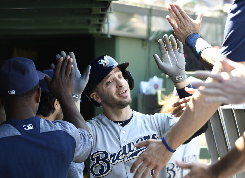 Milwaukee Brewers' Ryan Braun, center, is greeted in the dugout after hitting a home run against the Chicago Cubs during the second inning of a baseball game, Friday, Aug. 2, 2019, in Chicago. (AP Photo/David Banks)