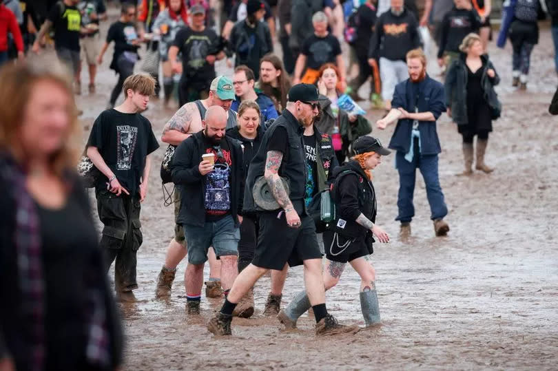 Festival-goers pictured in the mud at Download Festival