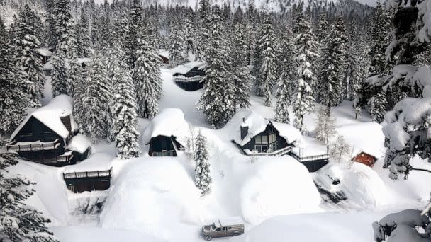 PHOTO: A vehicle navigates a snowy roadway lined with snowbanks piled up from new and past storms in the Sierra Nevada mountains, in the wake of an atmospheric river event, March 12, 2023, in Mammoth Lakes, California. (Mario Tama/Getty Images)