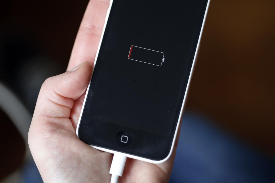 PARIS, FRANCE - DECEMBER 23:  In this photo illustration a woman holds an Apple mobile phone iPhone 5 on the screen of which we can see the battery charge indicator on December 23, 2017 in Paris, France. Apple has admitted that it was clamping the processors of old iPhone at certain stages of their life cycles, to deliberately slow down the performance of batteries of older models of iPhone.  (Photo by Chesnot/Getty Images)