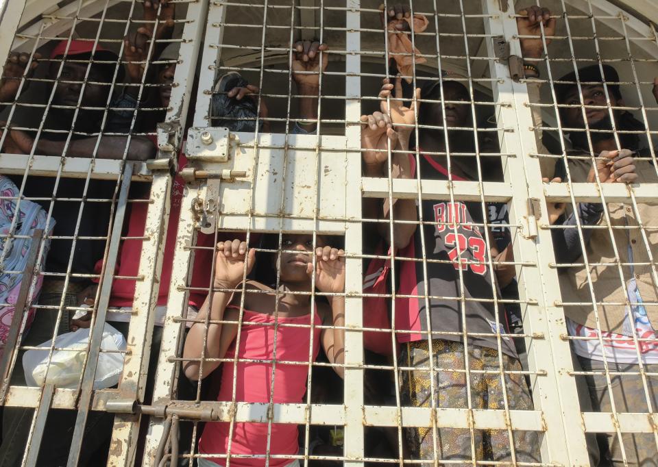 People who were detained for deportation to Haiti stand inside a police truck on the border bridge that connects Dajabon, Dominican Republic with Haiti, Monday, March 18, 2024. (AP Photo/Ricardo Hernandez)